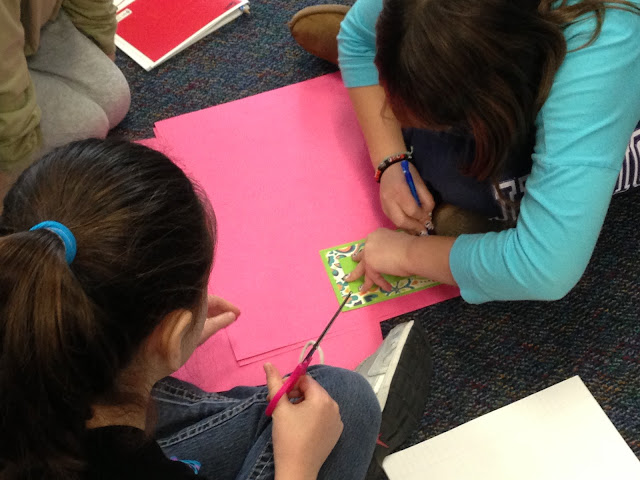 students tracing shapes to help them model fractions by folding equal parts